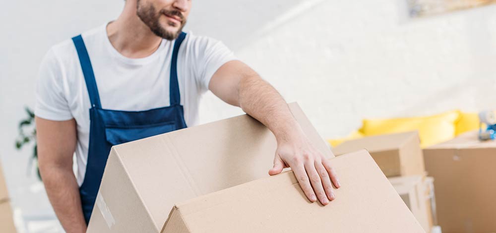 מוביל בפעולה במהלך הובלת דירה עם שני ארגזים גדולים